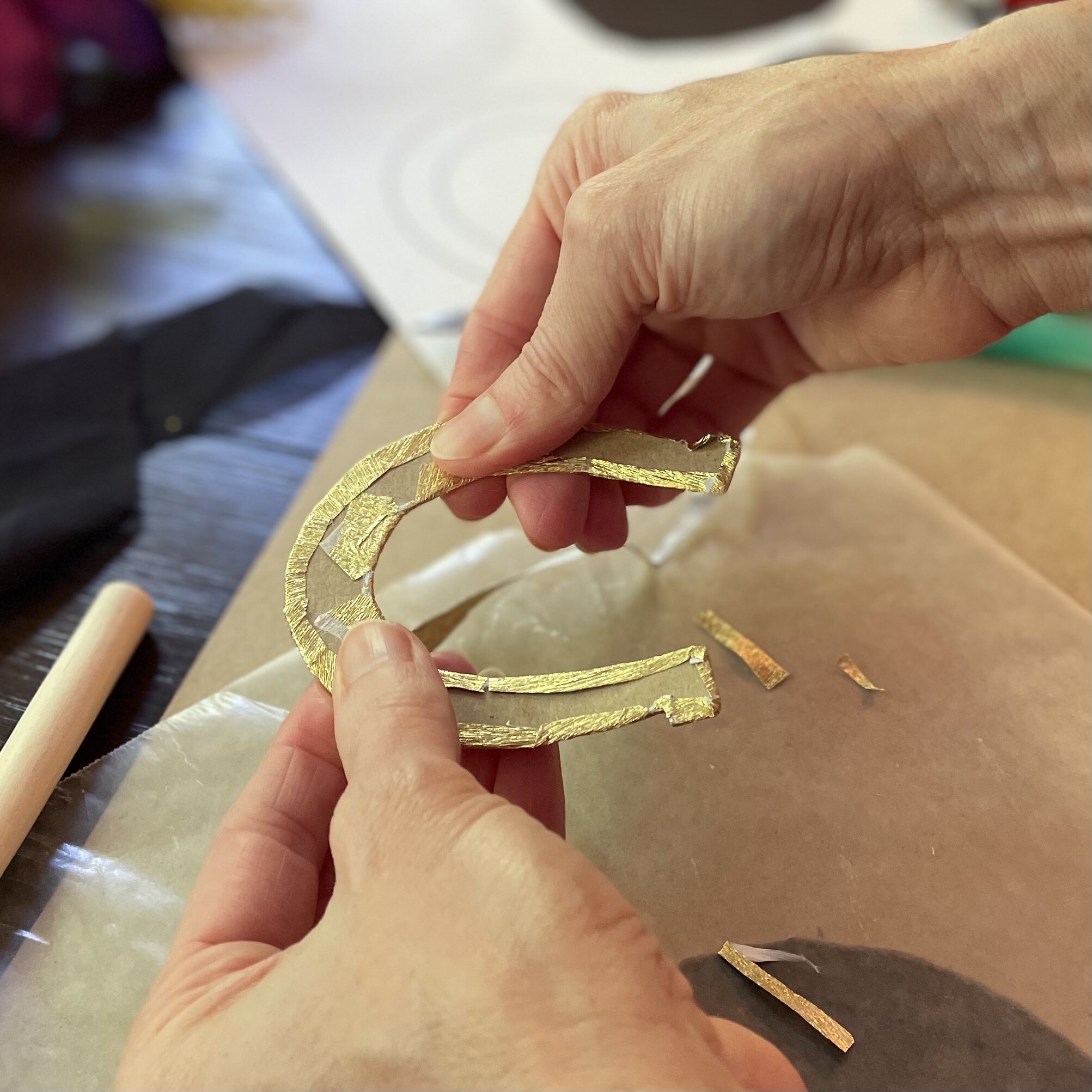 using mod podge and gold foil to make a horseshoe decoration for kentucky derby hat