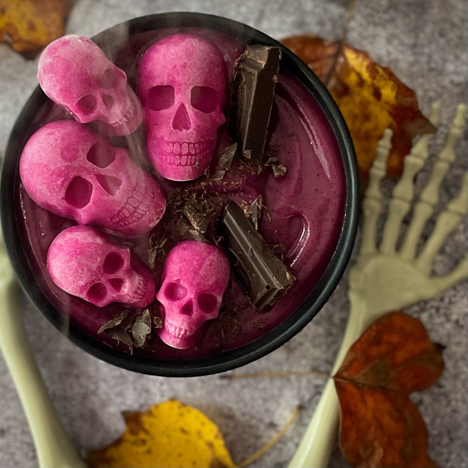 Halloween smoothie bowl made with purple sweet potatoes and garnished with dark chocolate and dragon fruit banana skulls that is vegan, dairy free and gluten free.