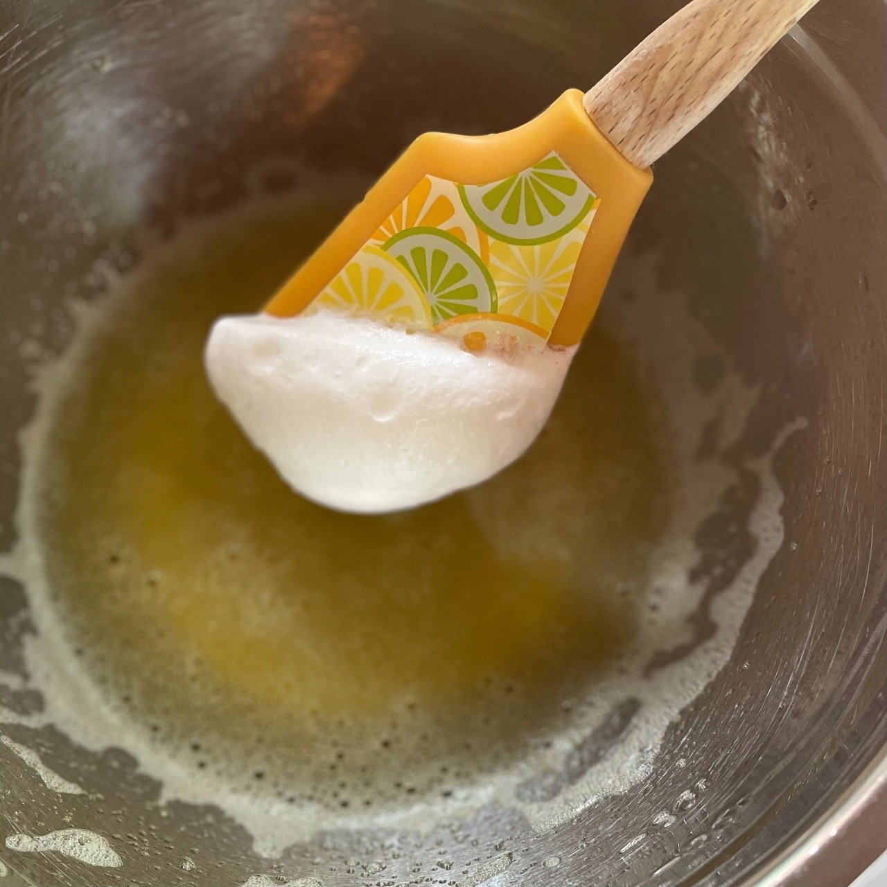 Incorporating whipped topping into lemon jello before folding in all to make a fluffy filling.