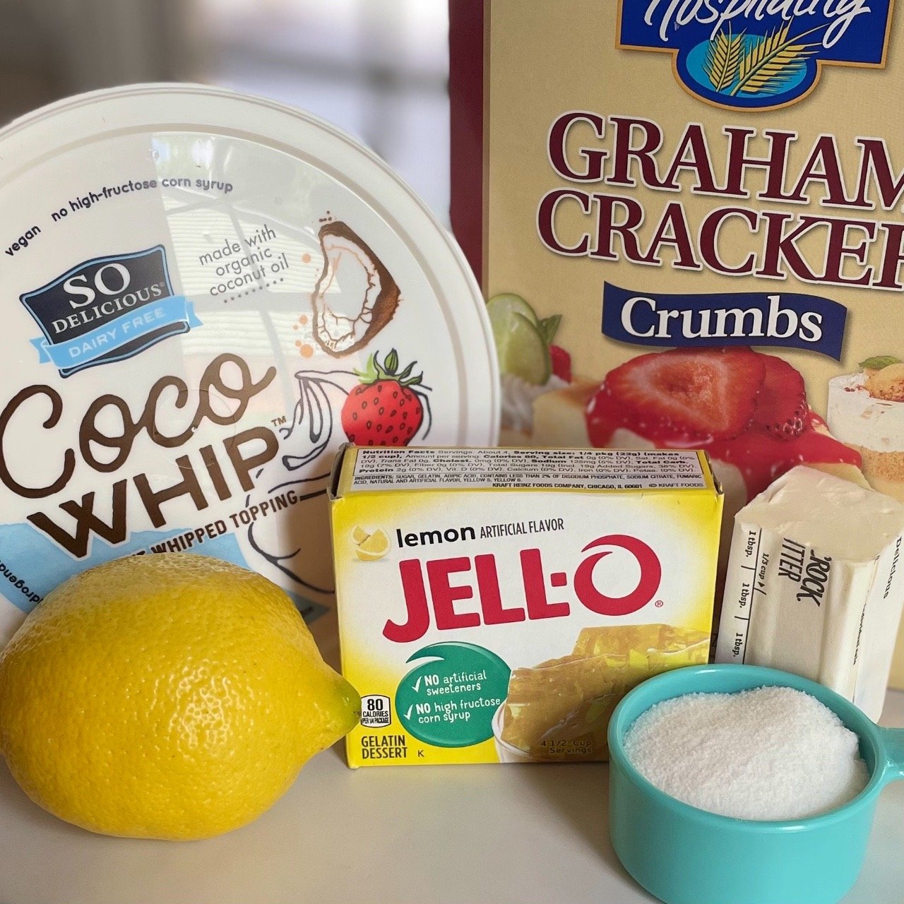 Ingredients to make lemon fluff icebox dessert using jello and whipped topping.